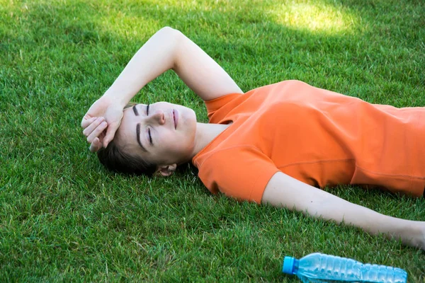 Egzersiz yaptıktan sonra parkta oturan memnun kız