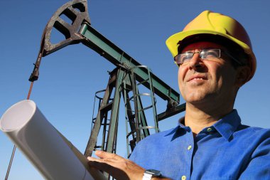 Petrol mühendisi sarı sabit hat ve bir petrol sahası planı ile delme yönetmenize arama, sondaj ve petrol üretim için ilgili teknik yönleri