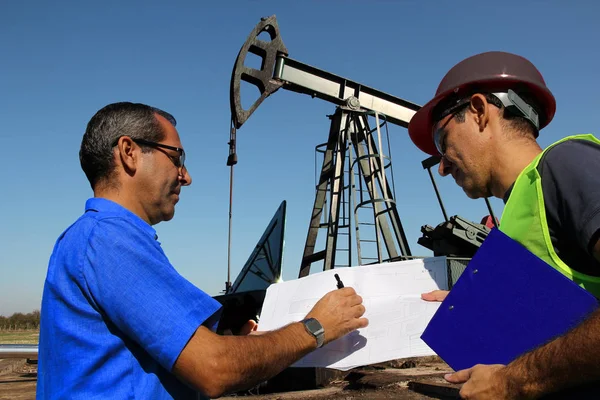 Ingenieros Petroleros Con Portátil Plano Campo Petrolífero Gestionan Los Aspectos Fotos De Stock Sin Royalties Gratis