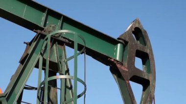 Mavi gökyüzü karşı bir petrol çıkarma sitesinde ham petrol pompa jack. Hd1080p