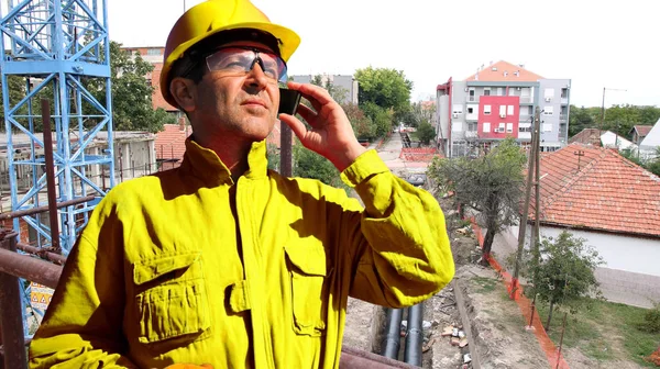 Construction Worker Yellow Personal Protective Equipment Using Smartphone Building Site — Stock Photo, Image