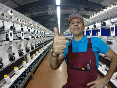 Başparmak gösterilmesini onarım çalışmaları sırasında tekstil fabrikasında sanayi işçisi