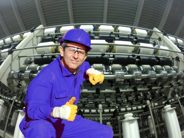 Çömelme ve başparmak gösterilmesini tekstil fabrikasında sanayi işçisi