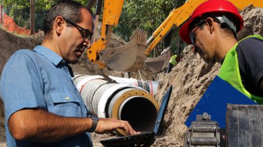  Dizüstü bilgisayar ve toplantı, planları inşaat sahasında tartışırken planları mühendisleri
