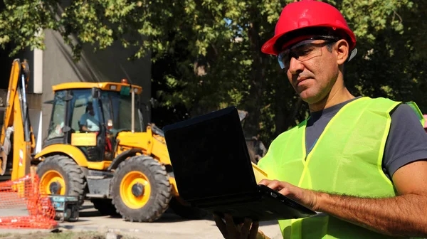 Інженер Використовує Ноутбук Перед Колісним Екскаватором Будівельному Майданчику — стокове фото