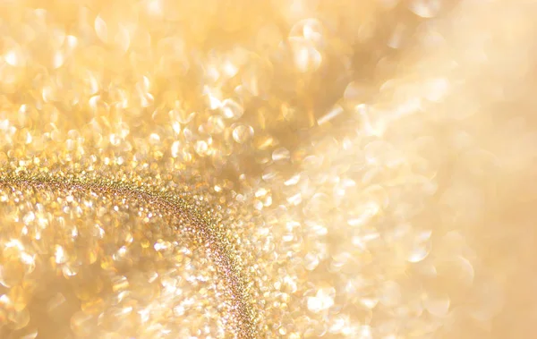 Gold Festive Christmas background. Abstract twinkled bright background with bokeh defocused golden lights