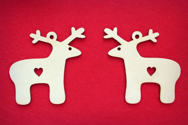 Two identical Christmas deer on textured red background.Free space for text. Christmas or new year cardn