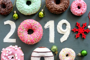 Metin 2019 tarafından renkli donutsand Noel oyuncaklar siyah vintage zemin, Yılbaşı Konsept çevrili.