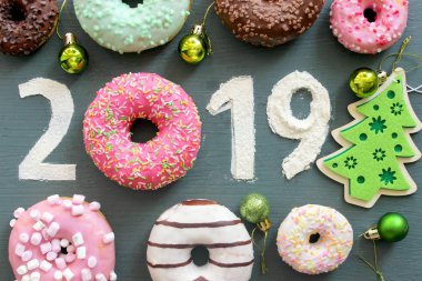 Metin 2019 tarafından renkli donutsand Noel oyuncaklar siyah vintage zemin, Yılbaşı Konsept çevrili.