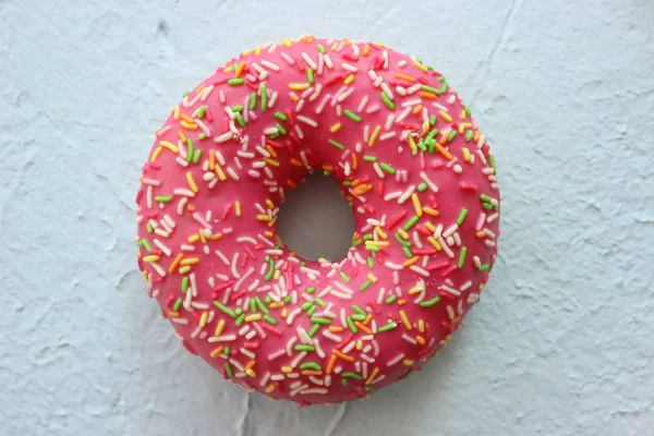 Розовый Пончик Разноцветными Посыпками Синем Текстурированном Фоне — стоковое фото