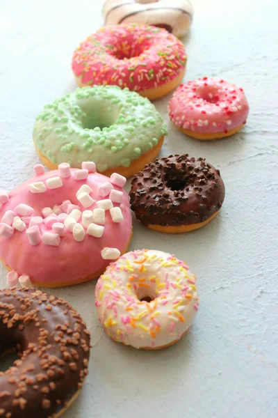別のドーナツの写真 ピンク グリーン チョコレートのアイシングのクローズ アップ 甘いデザートの盛り合わせのカラフルなドーナツ — ストック写真