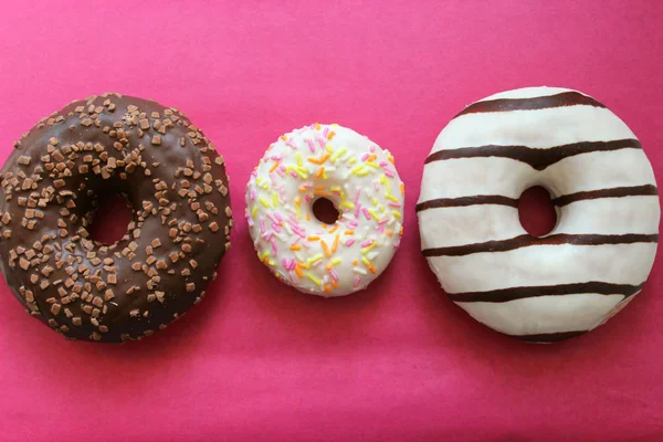 Chocolate Revestido Donuts Isolado Fundo Rosa Brilhante Perto — Fotografia de Stock