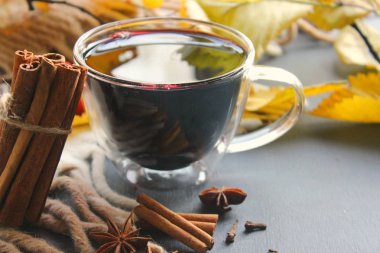 Bir fincan mulled şarap çevrili sarı sonbahar yaprakları ve baharatlar, tarçın, anason, karanfil. Sıcak ısınma içki, konfor, gevşeme içki rahatlatıcı,.