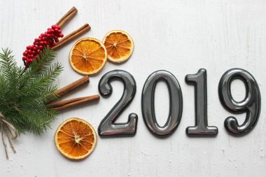 Noel kartı, çevrili Noel topları, çam dalları, tarçın, baharatlar, yakın çekim tarihi 2019 bir beyaz kağıt arka plan üzerinde kurutulmuş portakal, ahşap geyik. Kopya alanı.