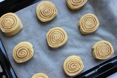 Güzel taze rulo tarçın. Pişirme işlemi. Taze kokulu hamur işleri. Çiğ hamur çörekler için. Yakın çekim.
