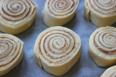 Güzel taze rulo tarçın. Pişirme işlemi. Taze kokulu hamur işleri. Çiğ hamur çörekler için. Yakın çekim.