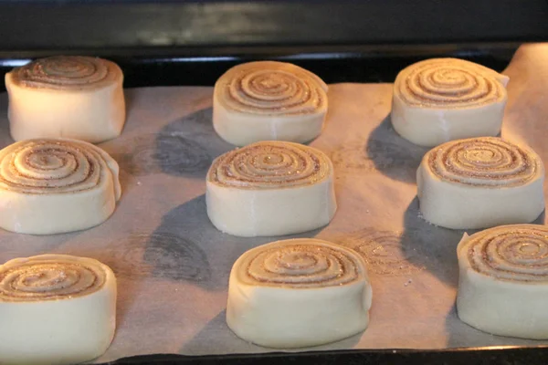 Beautiful fresh cinnamon rolls. The cooking process. Fresh fragrant pastries. Raw dough for buns.Close up.