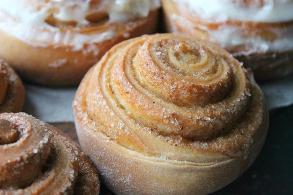 Güzel taze tarçın ruloları ahşap grunge doku masasına yakın çekim. Ev yapımı kekler, Cinnabon. Beyaz çay tabağında bir fincan çay, tarçın çubukları. Lezzetli Kahvaltı Büfesi.