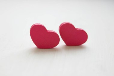 Sevgililer Günü konsepti. Sevgililer günü geçmişi. Beyaz ahşap arka plan üzerinde izole edilmiş iki pembe kalp. Kopya alanı. Metniniz için yer.