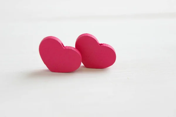 stock image The concept of Valentine`s day. Valentine`s day background. Two pink hearts isolated on white wooden background. Copy space. Place for your text.