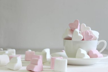 Pembe arka plan ile seramik fincan kalp şeklinde tatlı marshmallows. Aşk ve ilişki kavramı. Romantik Stil, Renkli tebrik kartı için yaratıcı. Sevgililer günü arka plan kalpleri, kopya alanı. Tasarım için Sevgililer Günü konsepti