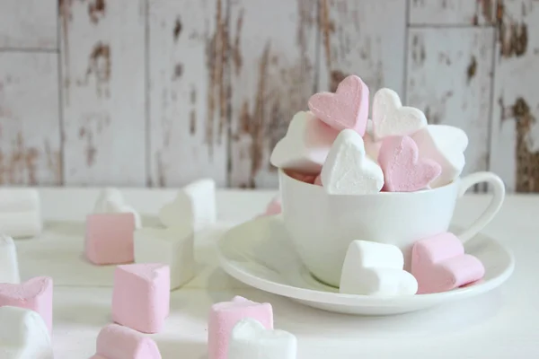 Pembe arka plan ile seramik fincan kalp şeklinde tatlı marshmallows. Aşk ve ilişki kavramı. Romantik Stil, Renkli tebrik kartı için yaratıcı. Sevgililer günü arka plan kalpleri, kopya alanı. Tasarım için Sevgililer Günü konsepti
