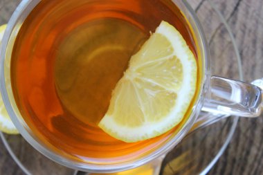 Ahşap arka planda limonlu bir fincan çay. Metniniz için alan kopyalama.