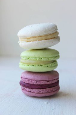 Renkli Fransız veya İtalyan makaron yığını kek / Macaroon kek. Çeşitli makarna kek hafif bir arka plan üzerinde üst üste yığılmış. Kopya alanı. Lezzetli tatlı.