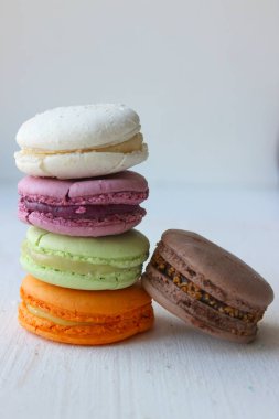 Renkli Fransız veya İtalyan makaron yığını kek / Macaroon kek. Çeşitli makarna kek hafif bir arka plan üzerinde üst üste yığılmış. Kopya alanı. Lezzetli tatlı.