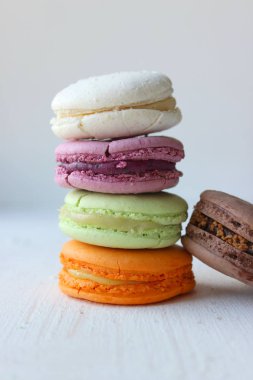 Renkli Fransız veya İtalyan makaron yığını kek / Macaroon kek. Çeşitli makarna kek hafif bir arka plan üzerinde üst üste yığılmış. Kopya alanı. Lezzetli tatlı.