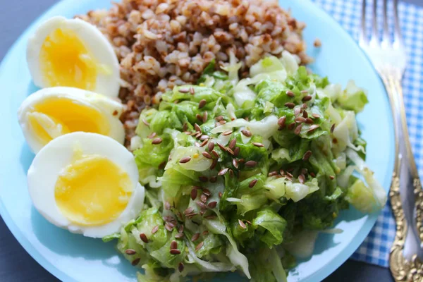 Sebzeli karabuğday. Ahşap bir arka plan üzerinde. Yukarıdan manzara. Kopya alanı. Koyu bir arka plan üzerinde yumurta, salata ve karabuğday lapası ile Sağlıklı Kahvaltı. Doğru beslenme. Diyet menüsü.