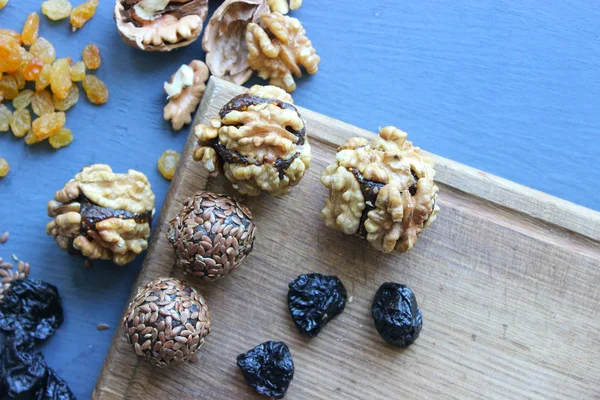 Homemade healthy raw vegan sweet balls with nuts,raisins, dates, cocoa and flax seeds. Healthy vegan food concept. Gray background.