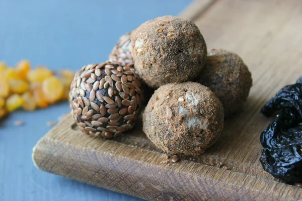 Homemade healthy raw vegan sweet balls with nuts,raisins, dates, cocoa and flax seeds. Healthy vegan food concept. Gray background.