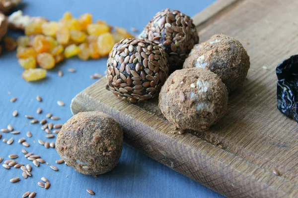 Homemade healthy raw vegan sweet balls with nuts,raisins, dates, cocoa and flax seeds. Healthy vegan food concept. Gray background.