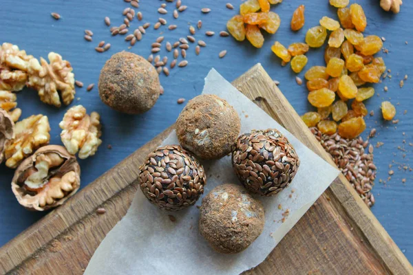 Homemade healthy raw vegan sweet balls with nuts,raisins, dates, cocoa and flax seeds. Healthy vegan food concept. Gray background.