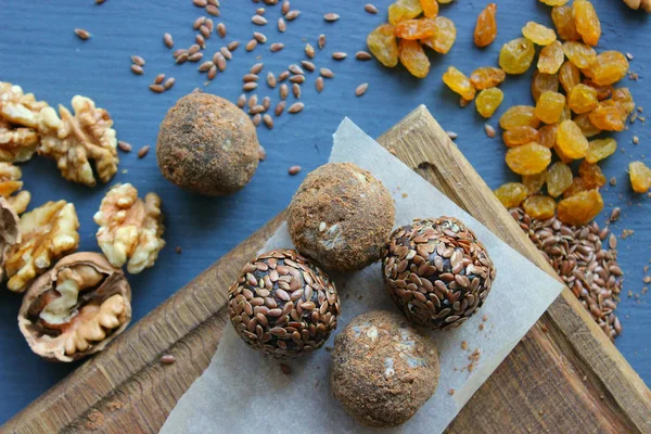 Fındık, kuru üzüm, hurma, kakao ve keten tohumu ile ev yapımı sağlıklı ham vegan tatlı topları. Sağlıklı vegan gıda konsepti. Gri arka plan.
