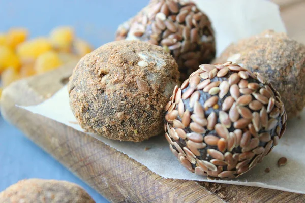 Homemade healthy raw vegan sweet balls with nuts,raisins, dates, cocoa and flax seeds. Healthy vegan food concept. Gray background.