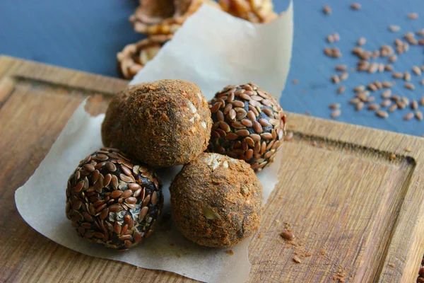 Homemade healthy raw vegan sweet balls with nuts,raisins, dates, cocoa and flax seeds. Healthy vegan food concept. Gray background.