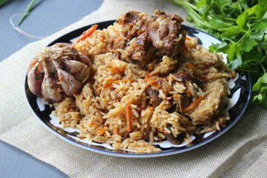 Doğu mutfağı kavramı. Ev yapımı Özbek kuzu pilavı yuvarlak bir tabakta servis edilir. Kopyalama alanı.