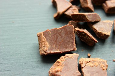 Ahşap tahta üzerinde lezzetli bitter çikolata parçaları