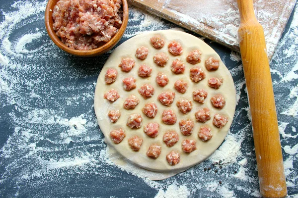 Ev yapımı köfte pişirme süreci. Ahşap bir tahta üzerinde ev yapımı ham ravioli. Köfte yapımı. Rus ulusal ev yapımı yemekler. Kopyalama alanı.
