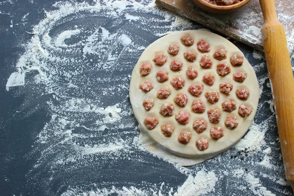 Ev yapımı köfte pişirme süreci. Ahşap bir tahta üzerinde ev yapımı ham ravioli. Köfte yapımı. Rus ulusal ev yapımı yemekler. Kopyalama alanı.