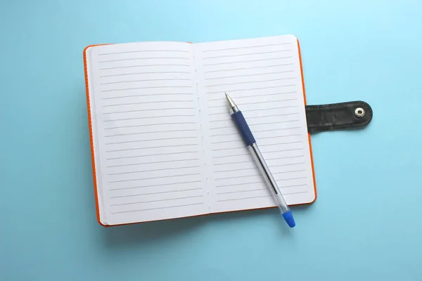 Blue blank open notebook on blue background with shadow .Top view of an open empty notebook on a colorful table. Copy space.