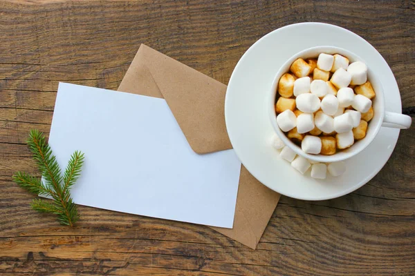 Coupe avec boisson maison au chocolat chaud de Noël, guimauves et carte de vœux de vacances sur fond en bois . — Photo