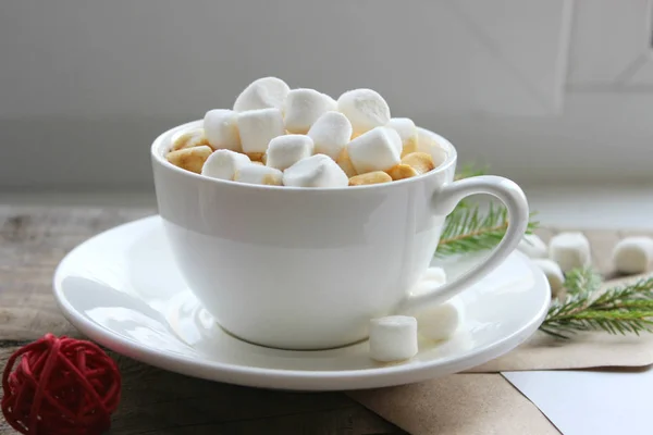 Cappuccino med marshmallows i beger på brunt trebord – stockfoto