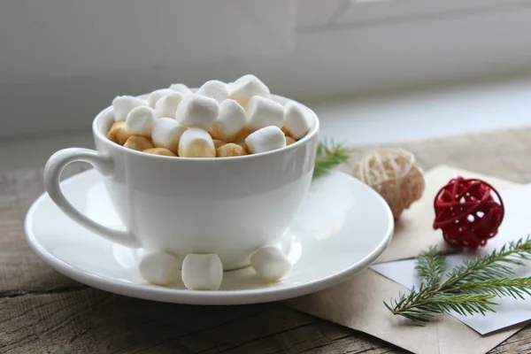 Cappuccino med marshmallows i cup på brunt träbord — Stockfoto