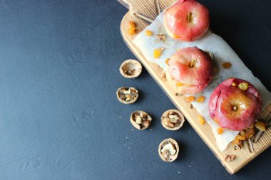 Koyu bir arka plan üzerinde tarçın, ceviz ve bal ile pişmiş kırmızı elma. Ceviz Bal Sağlıklı Bir Diyet Gıda mı.