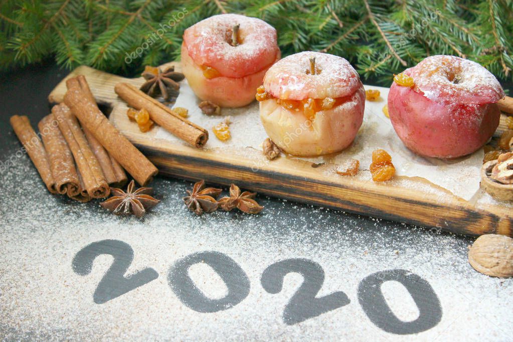 New year 2020, numbers written in flour on table. baked apple with christmas spices on wooden background