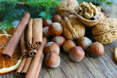 Noel dekoru. Noel baharatları. Tarçın çubukları, anason yıldız, ceviz, fındık, eski bir ahşap arka plan üzerinde kurutulmuş portakal, kopya alanı.