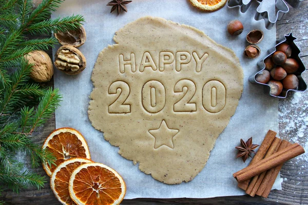 Mesaj 2020. Yeni yıl kavramı 2020. Noel pastaları. Yeni yıl ve Noel için ev yapımı kekler veya kurabiyeler. Resimler, fındıklar, kurutulmuş portakallar, köknar dalları, ahşap arka plan. Kırsal tarzda. Yeni yıl, Noel arkaplanı.
